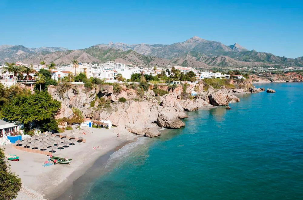 Playa de la Costa del Sol en Málaga, con la orilla y bañistas al atardecer